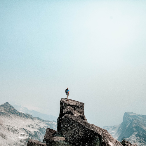 Person Standing on Top of a Mountain