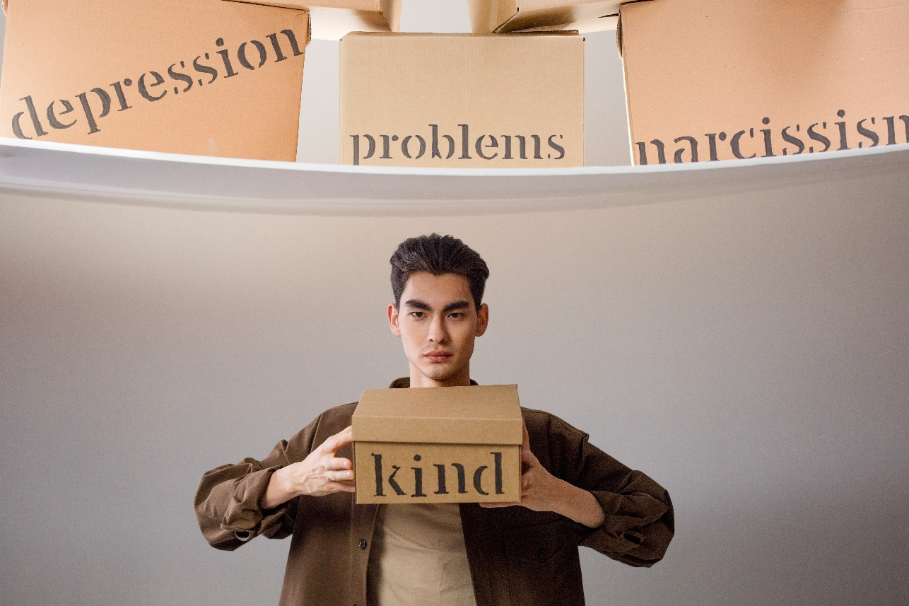 A man holding a box that says kind
