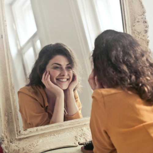 A woman smiling at her reflection