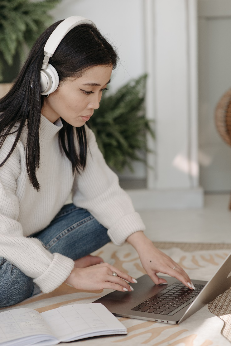 a woman listening to music while working on her laptop