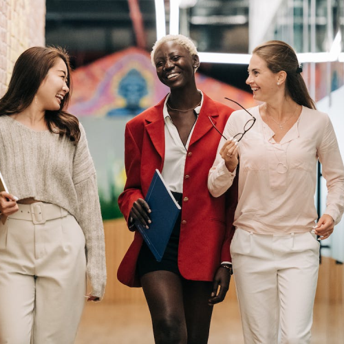 Three colleagues engaged in friendly conversation while walking